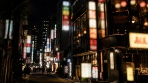 夜の繁華街に並ぶネオン看板と飲食店が入る雑居ビルのイメージ