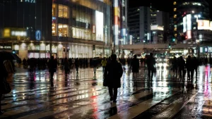 夜のターミナル駅前の交差点を行き交う人々